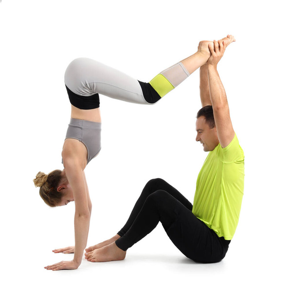 Sporty couple practicing yoga on white background - Foto, Imagen