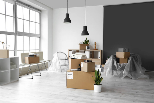 Cardboard boxes with belongings in interior of office on moving day - Photo, image