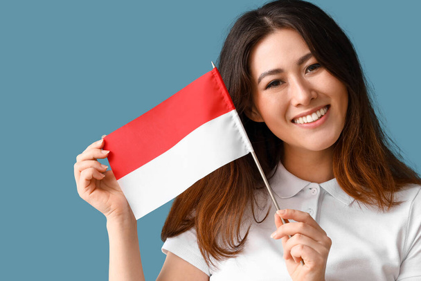 Fiatal ázsiai nő zászló Indonézia kék háttér - Fotó, kép