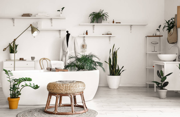 Interior de baño ligero con bañera, maniquí y plantas de interior - Foto, Imagen