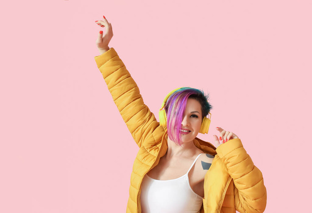Bella donna con capelli insoliti ascoltare musica su sfondo rosa - Foto, immagini