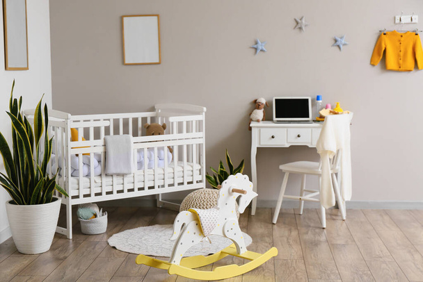Interior of light children's room with baby crib and table - Photo, Image