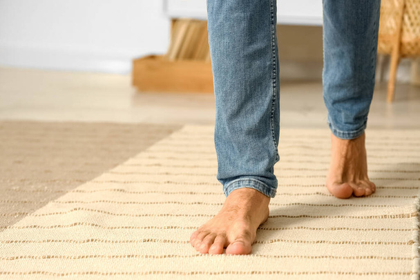 Bare feet of young man walking at home, closeup - Photo, Image