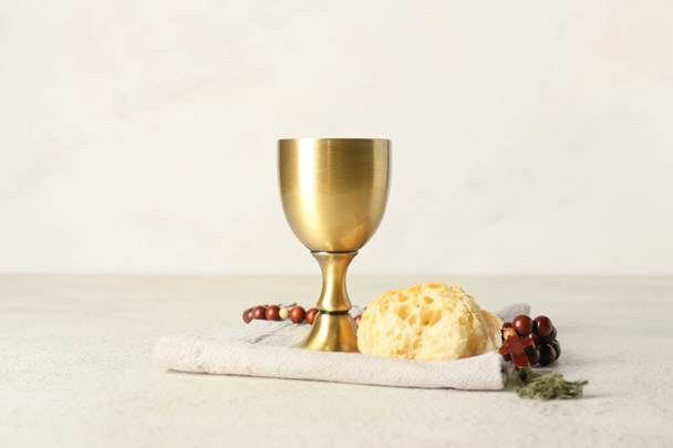 Чашка вина с хлебом и четками на светлом фоне - Фото, изображение