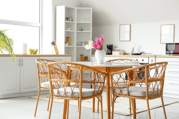 Elegante interior de cocina con mesa de comedor y flores de jacinto - Foto, imagen