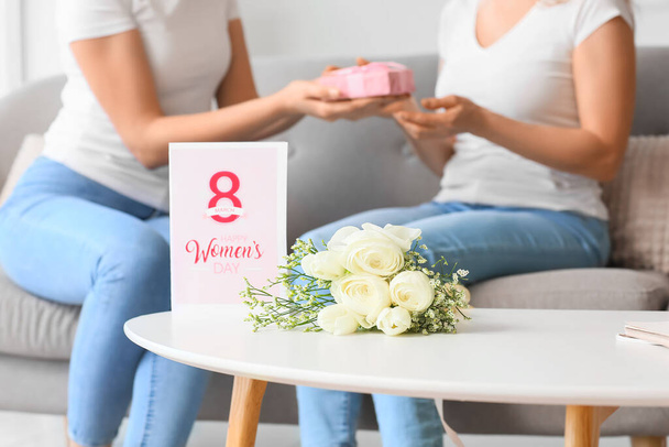 Букет цветов и поздравительные открытки на Международный женский день на столе дома - Фото, изображение