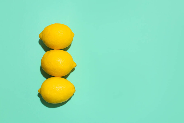 Ripe lemons on turquoise background - Фото, изображение