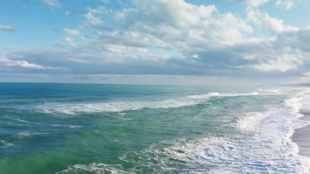 Pobřeží s bouřlivými vlnami vody a mraky na obloze - Záběry, video