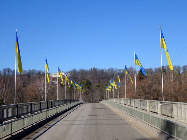                   Spousta ukrajinských vlajek na mostě přes řeku Gauju u Siguldy              - Fotografie, Obrázek
