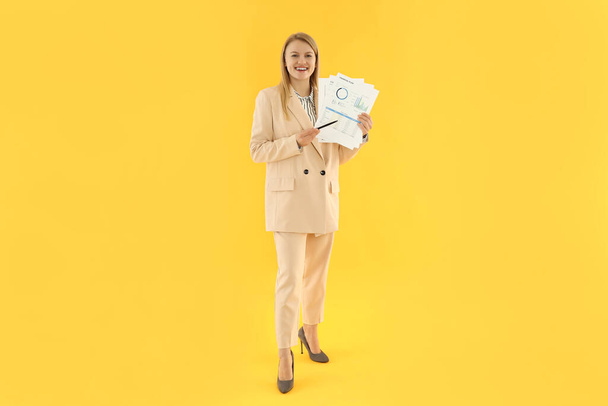 Geschäftskonzept mit junger attraktiver Geschäftsfrau auf gelbem Hintergrund - Foto, Bild