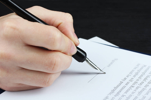 De hand van de vrouw tekent document close-up. Ondertekening van het contract. Handtekening. - Foto, afbeelding