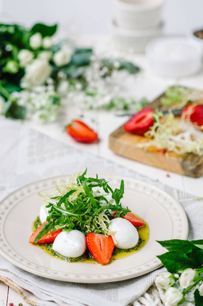 Light summer fresh salad. Buffalo mozzarella with strawberries, pesto, arugula and lettuce. - Foto, Imagem