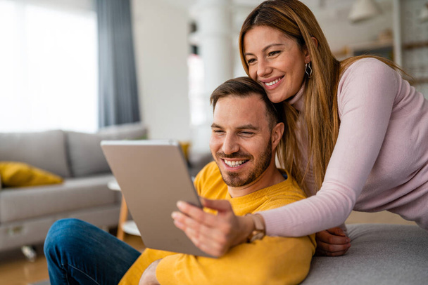 Young couple in love at home enjoying together, using tablet - Foto, immagini