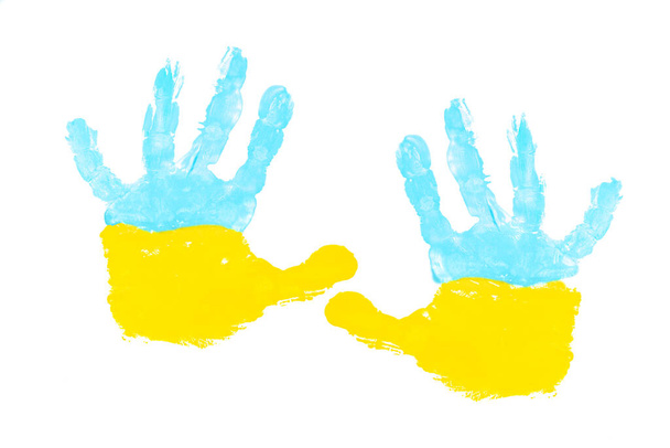 Pitture gialle e blu del palmo di un bambino isolato su bianco. Simboli bandiera ucraina concetto. - Foto, immagini