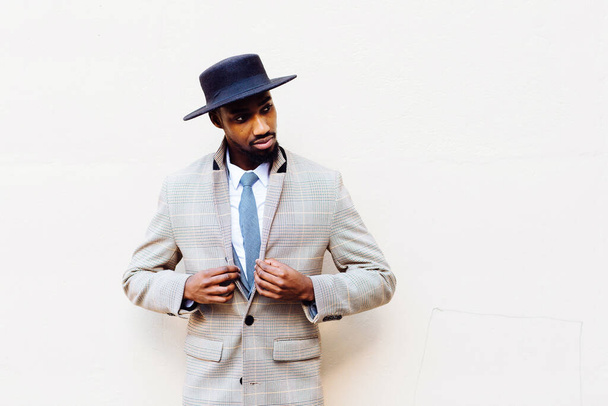 portré egy jóképű afro-amerikai férfi kalap és öltöny könnyű háttér - Fotó, kép