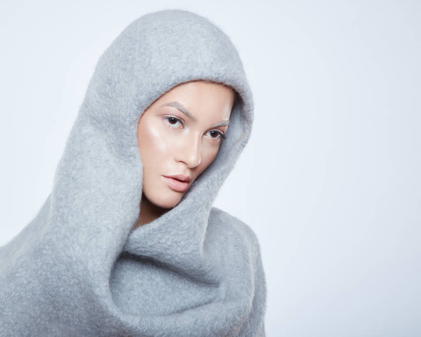 Closeup profile portrait of a female model in a wool hood with makeup, have closed eyes, isolated on a white background. Horizontal view. Copy space. - Foto, imagen