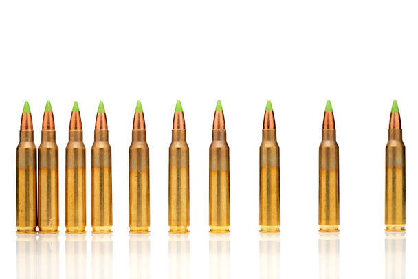 Eine Gruppe von 5,56 kalibar-, grüne Spitze Kugeln in die Linie auf weißem Hintergrund bestellt - Foto, Bild