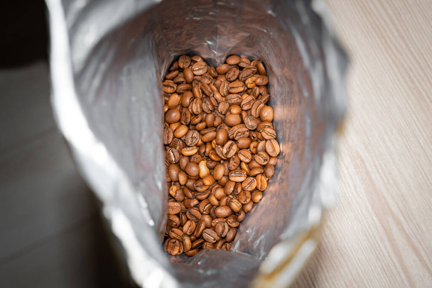 Pose de grains de café au fond d'un sac métallique spécial - Photo, image