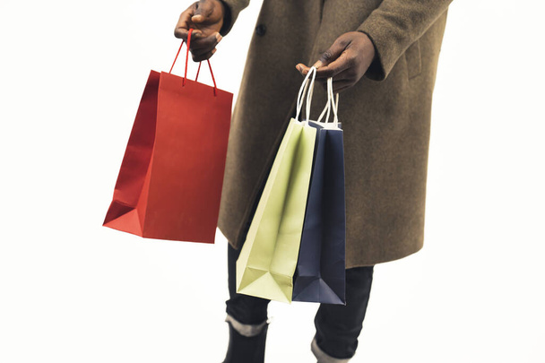 colorful shopping bags black-skinned man white background - close-up shot - Foto, immagini