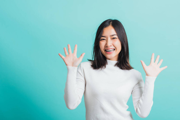 Young beautiful Asian woman cheerful smiling makeup showing open hands, Portrait happy female shocked she shows palms, studio shot isolated on a blue background - Fotoğraf, Görsel