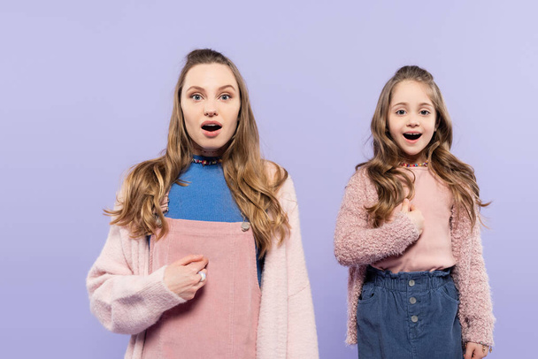 amazed mother and daughter pointing at themselves isolated on purple  - Photo, Image