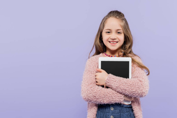 joyful girl hugging digital tablet with blank screen isolated on purple - Photo, Image
