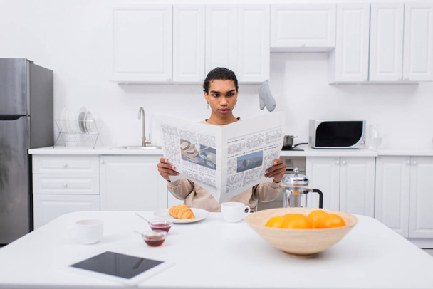 african american man reading newspaper near morning breakfast and digital tablet on table - Zdjęcie, obraz