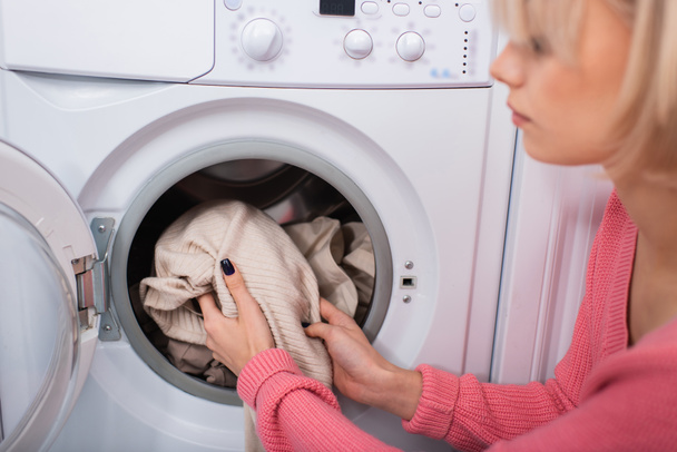 niewyraźne kobieta wprowadzenie ubrania do pralki - Zdjęcie, obraz