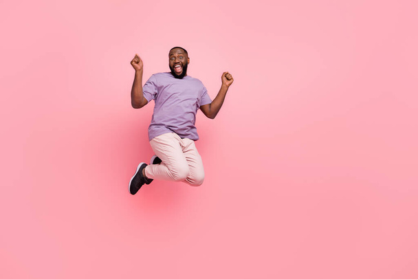 Full length body size view of attractive cheerful lucky guy jumping having fun isolated over pink pastel color background - Foto, afbeelding