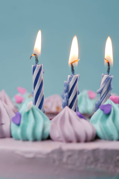 αργή κίνηση της καύσης κερί σε μια τούρτα γενεθλίων σε ανοιχτό μωβ φόντο  - Φωτογραφία, εικόνα