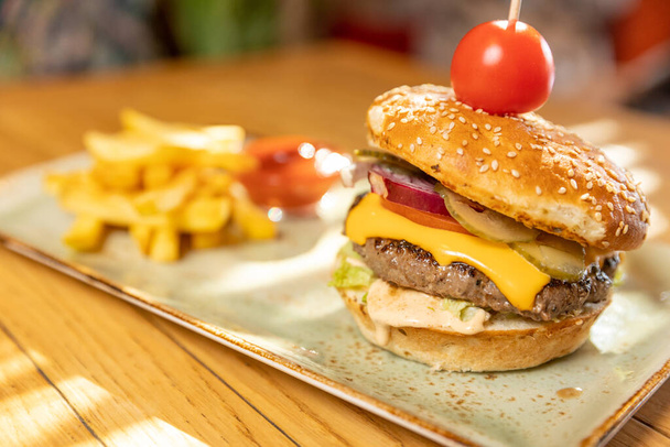 Deliciosa hamburguesa servida con papas fritas en el restaurante - Foto, imagen