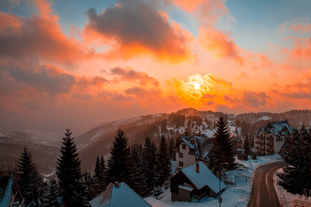 Golden hour in mountain village on cloudy winter day. Above scenery view background - Foto, imagen