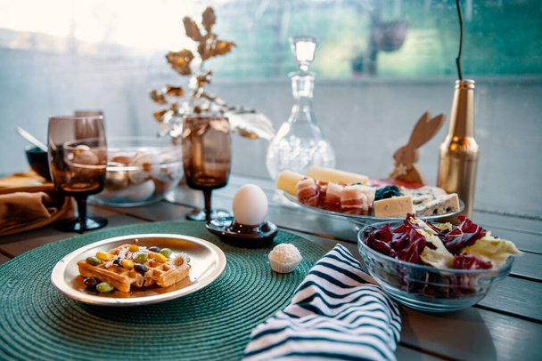 Накрытие стола в зеленых пастельных тонах с пасхальной едой и цветами тюльпана на весенний завтрак - Фото, изображение