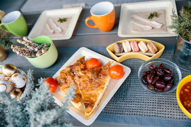 Pasen brunch maaltijd in biologisch afbreekbare bamboe borden serveren op balkon tafel. Verscheidenheid van voedsel voor Vakantie ontbijt plat lag van boven - Foto, afbeelding