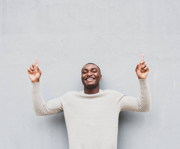 Ritratto di uomo afroamericano felice che punta il dito verso l'alto  - Foto, immagini