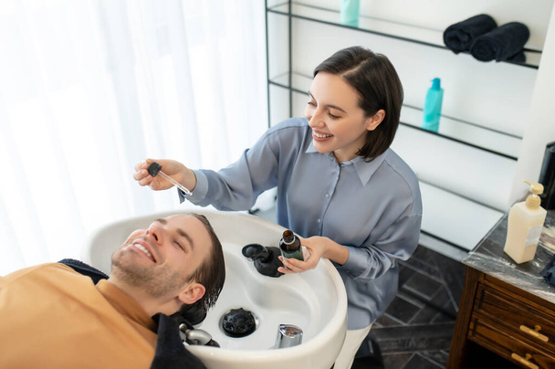 Beautician applying revitalizing hair drops to the clients head - Fotografie, Obrázek
