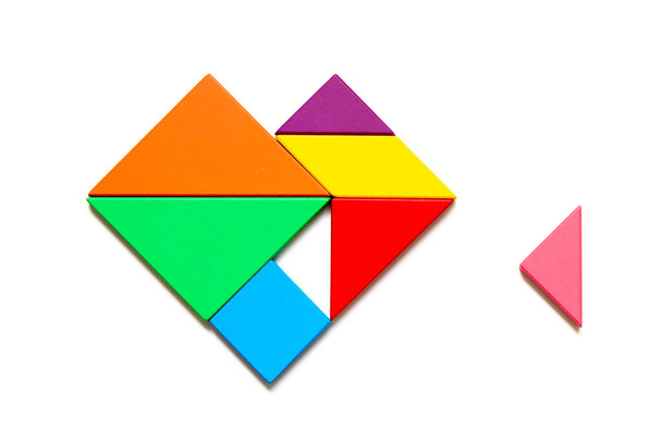 Farb-Tangram-Puzzle in Herzform, das auf weißem Hintergrund auf seine Erfüllung wartet - Foto, Bild