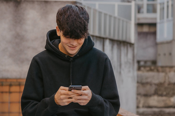 Teenager mit Handy oder Smartphone auf der Straße - Foto, Bild