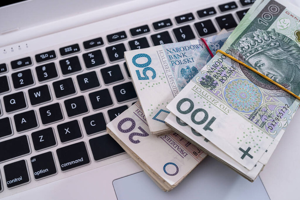 pln полировать деньги на белом ноутбуке клавиатуры. онлайн бизнес и финансовая концепция - Фото, изображение