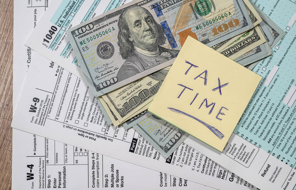 税とドルの支払いに関する問題がある1040の納税申告書のトップビューです。米国の形態の概念と税金の支払い - 写真・画像