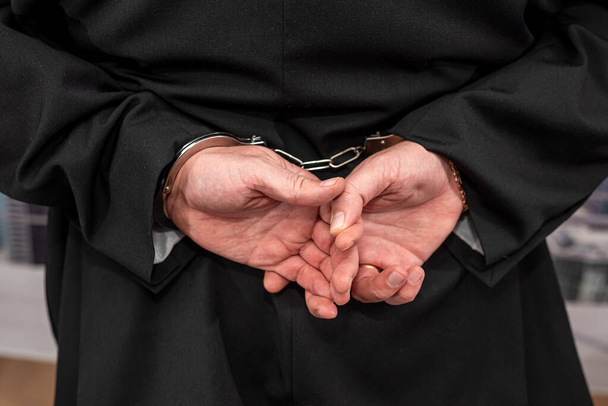 Ein junger Mann in dunklem Anzug wird wegen gefälschter Dollarscheine festgenommen. Das Konzept der illegalen Dollarnoten - Foto, Bild
