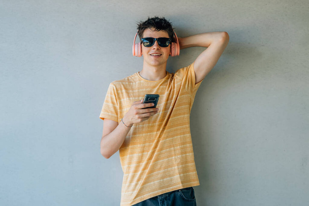 nuori mies, jolla on kuulokkeet ja matkapuhelin - Valokuva, kuva