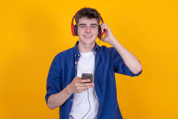 έφηβος με ακουστικά και κινητό τηλέφωνο απομονωμένο - Φωτογραφία, εικόνα