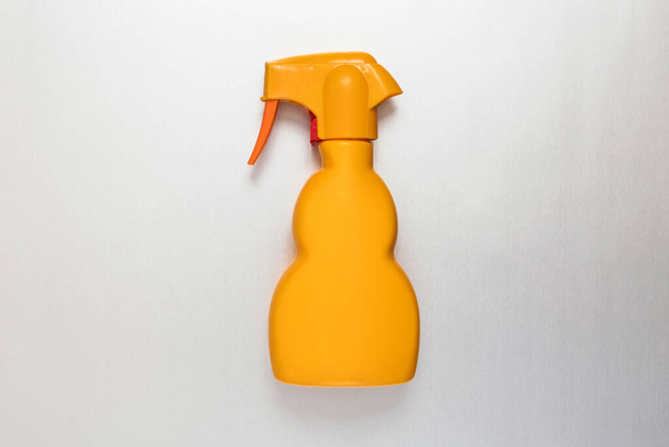 Ogólna nieoznakowana żółta plastikowa butelka z aerozolem leżąca płasko na białym tle w koncepcji opakowań detalicznych i higieny gospodarstw domowych z przestrzenią do kopiowania - Zdjęcie, obraz