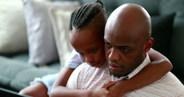 Ребенок обнимает отца, пока он работает дома, искренняя семейная привязанность - Фото, изображение