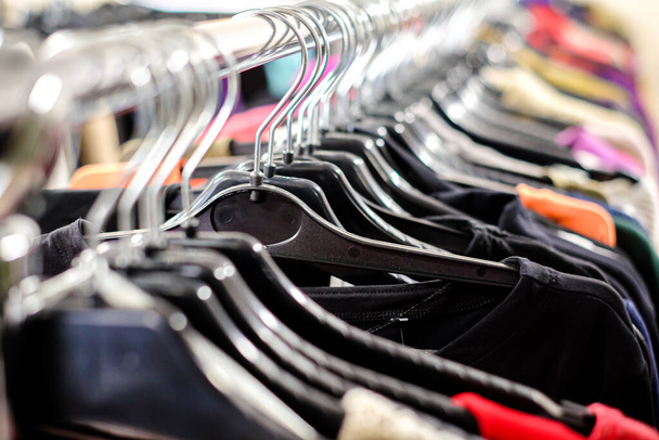 Second hand clothes store. Vintage clothes on the hangers. Defocused - Photo, Image