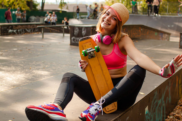 Усміхнена дівчина-підліток зі скейтбордом портрет на відкритому повітрі
. - Фото, зображення