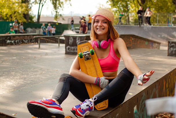 Adolescente souriante avec portrait de skateboard en plein air. - Photo, image