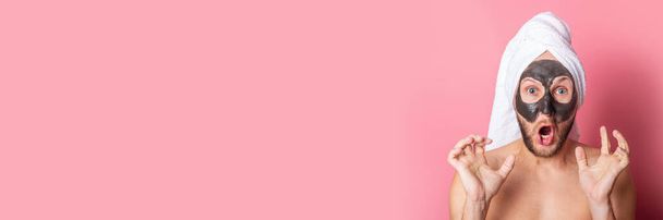 hombre joven gritando con máscara cosmética en su cara sobre un fondo rosa. Cuidado, limpieza. Banner. - Foto, imagen