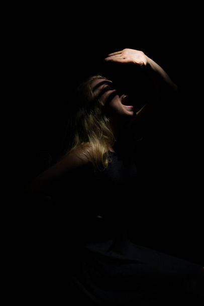 Dnepropetrovsk, Ucrania - 11.07.2016: El juego de la luz y la sombra. Rubia con el pelo largo en una habitación con iluminación inusual. - Foto, imagen